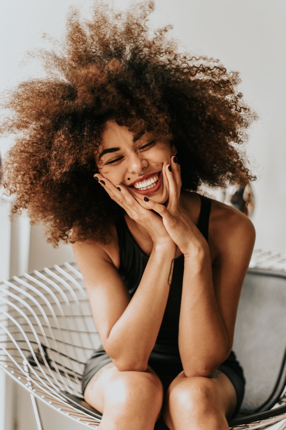 Janelle, laughing with her hands framing her face